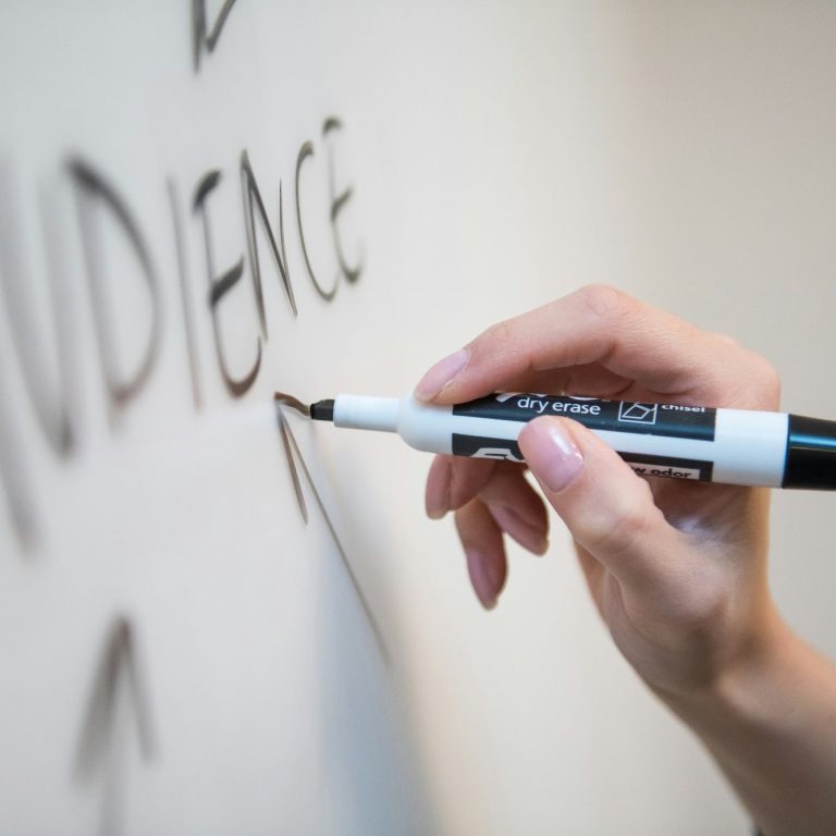 A hand writing on a whiteboard